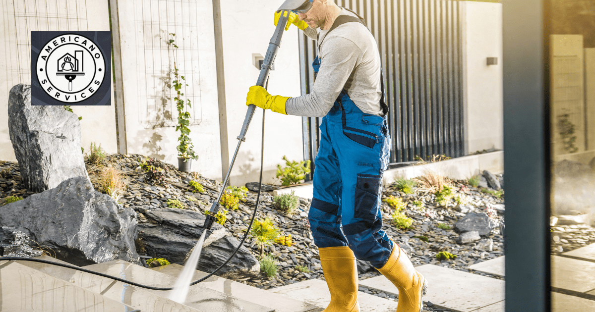 A man in blue overalls and yellow rubber boots holding a hose.
