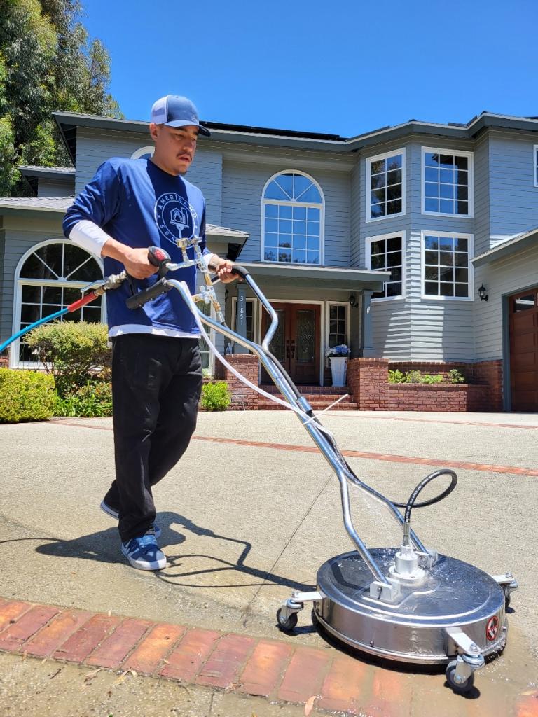 A man is using a large metal surface cleaner.