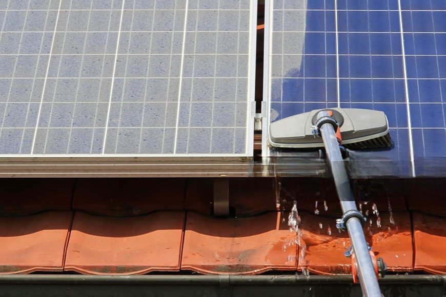 Cleaning solar panels with a brush.