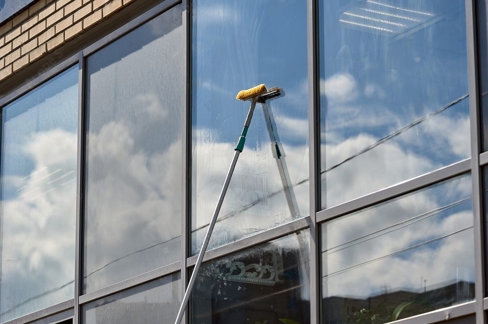 Window cleaning with squeegee and pole.