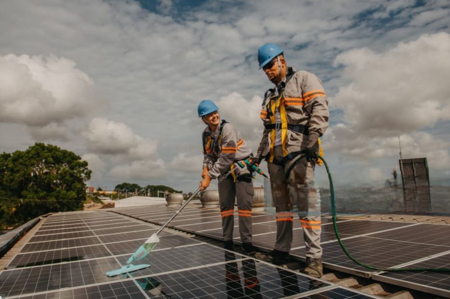 Two workers cleaning solar panels.