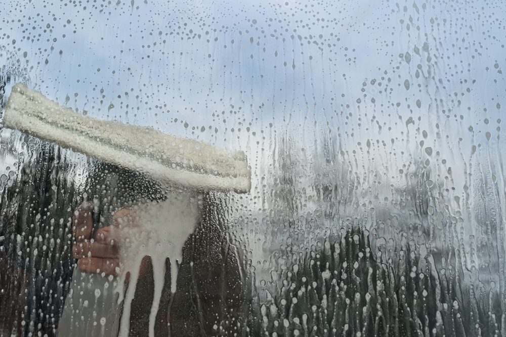 Window cleaning with a squeegee and soap.