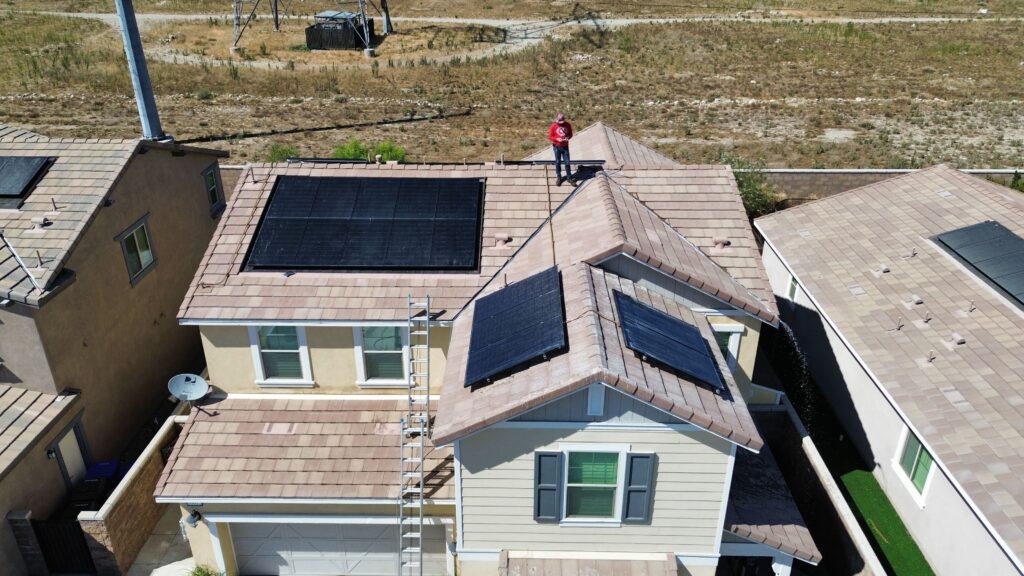 Man on roof with solar panels.