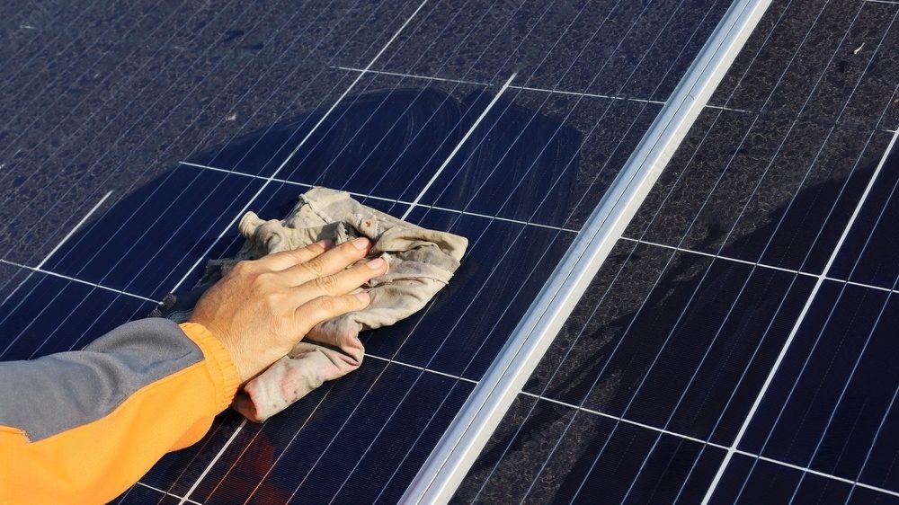 Cleaning solar panels with a rag.